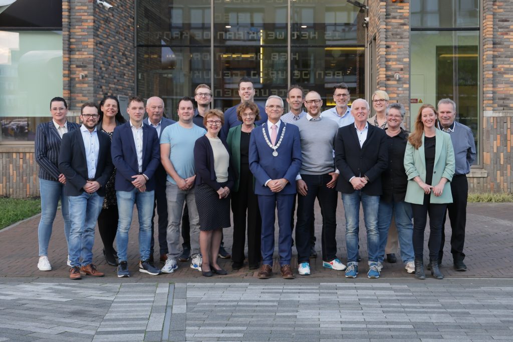 De gemeenteraad van Drechterland met in hun midden burgemeester Pieter Dijkman en griffier Andrea van langen poseert voor het gemeentehuis